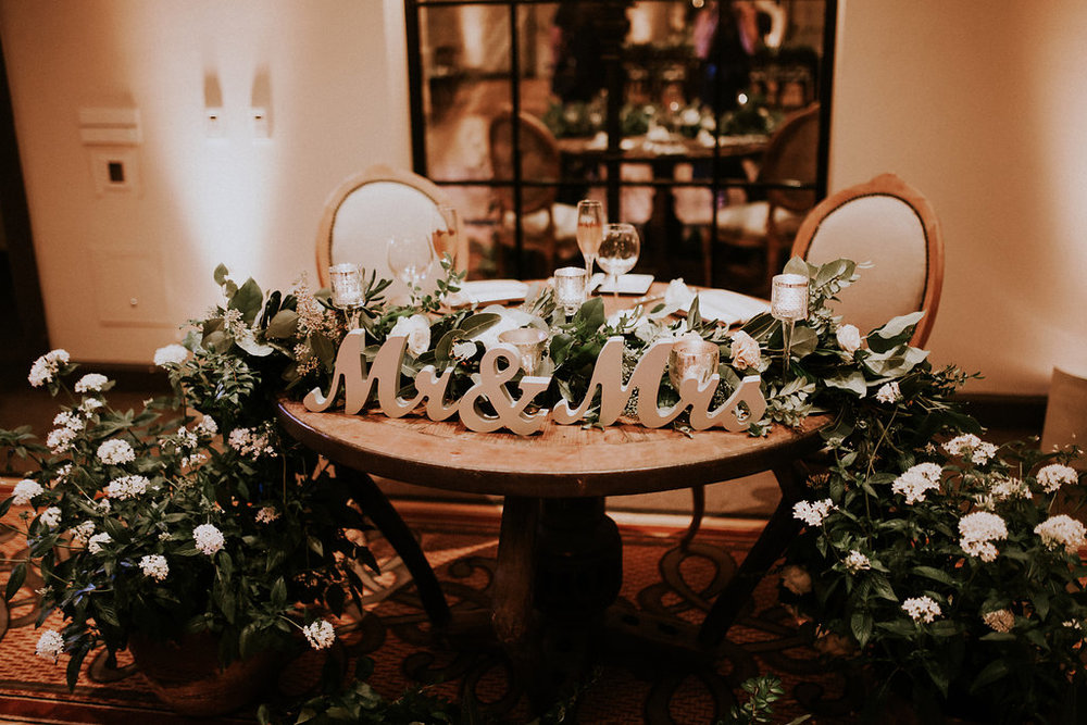 Sweet Blossom Weddings Team moved this garland from the arch to the Sweetheart Table Florist: Native Poppy Photographer: Amy Lynn Photography