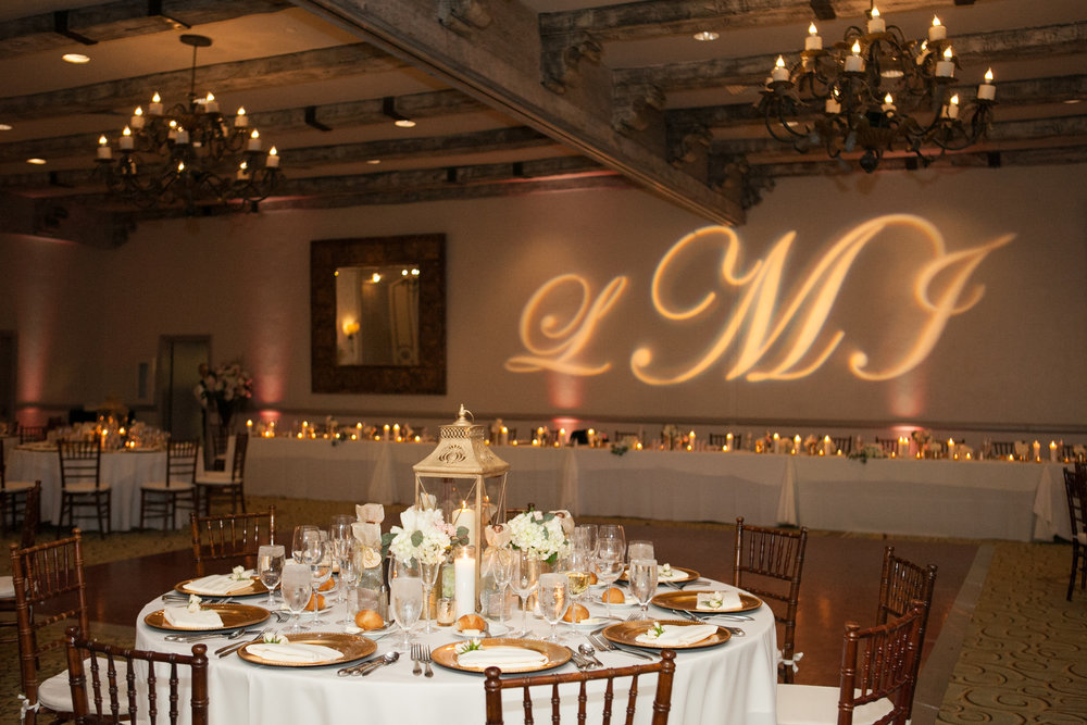 Gobo with the bride and groom's initials taking up the wall behind the bridal table