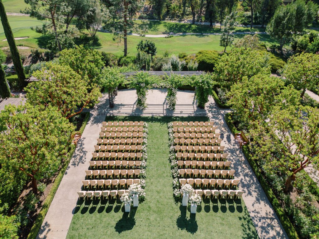 a wedding ceremony set up and decor, birds eye view before ceremony, wood chairs and white florals