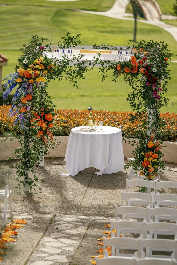a colorful jewish wedding ceremony overlooking a golf course