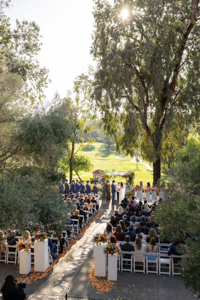 bride and groom standing under a chuppah during their wedding ceremony overlooking the golf course at rancho bernardo inn